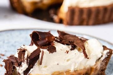A close-up of a Banoffee pie slice on a blue plate.