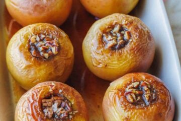 Baked apples filled with cinnamon sugar in a rectangular baking dish.