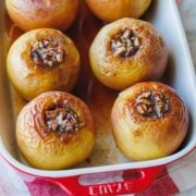 Baked apples filled with cinnamon sugar in a rectangular baking dish.