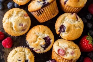 Fluffy and moist Mixed Berry Muffins come together quickly and are loaded with juicy strawberries, raspberries and blueberries. Easy, excellent berry muffin recipe! #muffins #berrymuffins #strawberrymuffins #blueberrymuffins #raspberrymuffins #berrymuffinrecipe #howtomakemuffins #easymuffins #breakfastmuffins #natashaskitchen #dessert #berries #triberrymuffins #tripleberrymuffins #strawberries #blueberries #raspberries