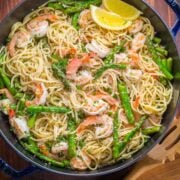 shrimp scampi pasta served with asparagus and lemon wedges