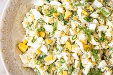 Potato salad sprinkled with dill in beige bowl