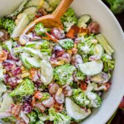 Finished broccoli grape salad in a serving bowl with mixing spoon