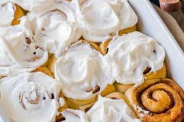 cinnamon rolls in casserole dish with icing on top
