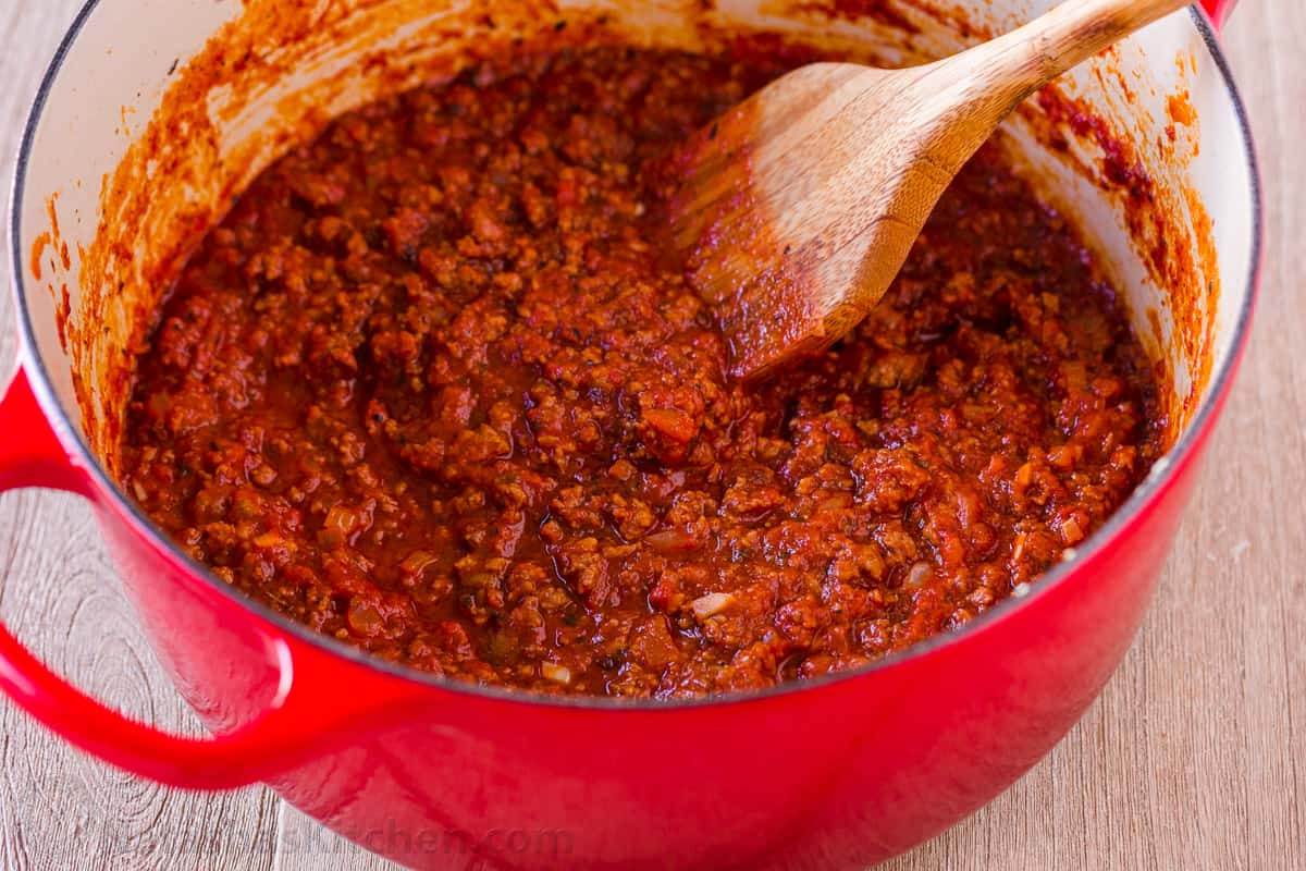 My Lasagna Roll Ups taste as good as my classic Lasagna (beefy, saucy, and cheesy), but are easier to serve. Make-ahead & freezer-friendly. spoon stirring a Ragu ground beef meat sauce in a red dutch oven