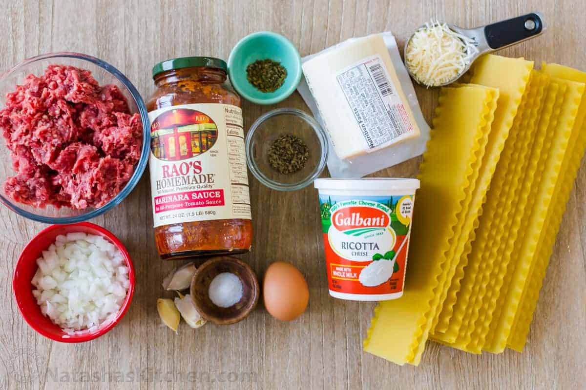 My Lasagna Roll Ups taste as good as my classic Lasagna (beefy, saucy, and cheesy), but are easier to serve. Make-ahead & freezer-friendly. Ingredients for lasagna roll ups recipe on a table including lasagna noodles, marinara sauce, ground beef, ricotta cheese, mozzarella cheese, garlic, spices. and parmesan cheese