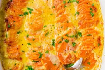 Scalloped Sweet Potatoes in casserole dish with serving spoon