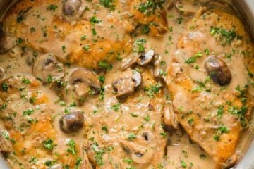 Finished Chicken Marsala Recipe topped with mushroom and parsley in a pan.