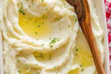 Instant Pot Mashed Potatoes in a casserole dish drizzled with butter