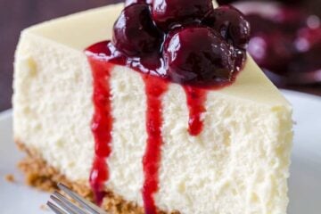 Slice of cheesecake on a plate topped with cherry sauce