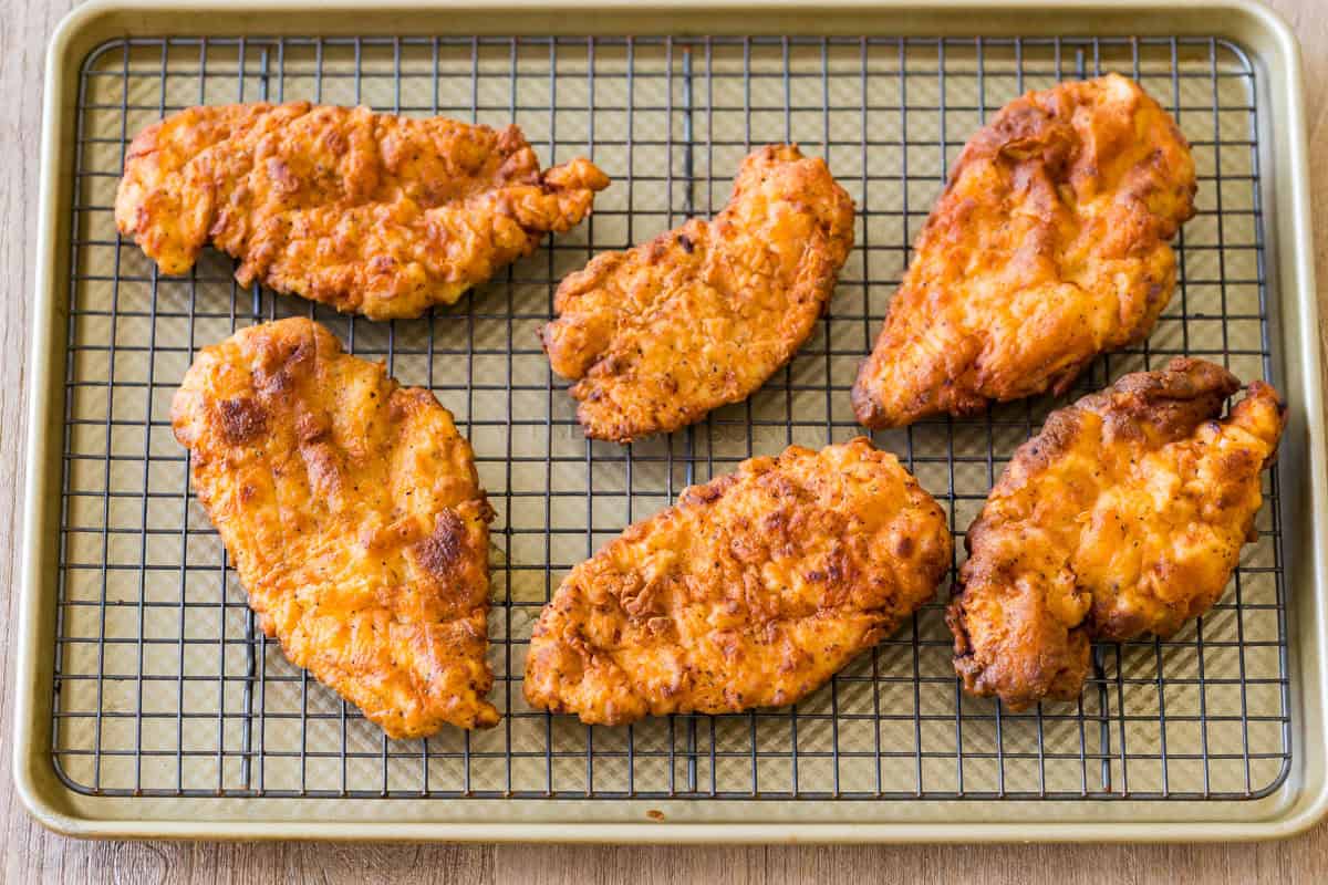 crispy chicken patties draining on a wire rack. 