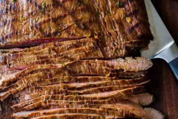 Sliced carne asada on cutting board