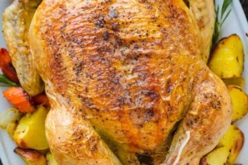 Whole Roast Chicken on a platter with vegetables