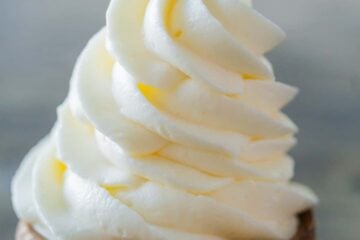 Cream cheese frosting piped onto spoon