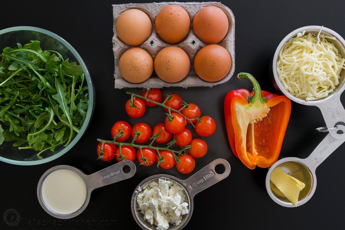 ingredients for frittata recipe with eggs, cream, cheese, and vegetables
