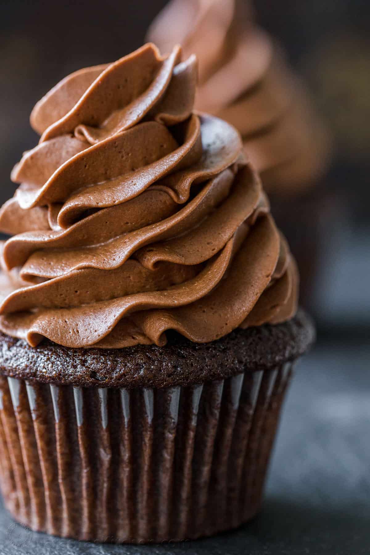 Easy Chocolate Cupcake recipe with bakery results at home! This cupcake is chocolatey, moist, perfectly domed, and incredibly easy! Frosted cupcake with chocolate buttercream