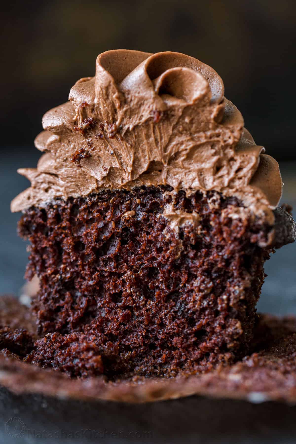 Easy Chocolate Cupcake recipe with bakery results at home! This cupcake is chocolatey, moist, perfectly domed, and incredibly easy! Fluffy and moist center of a chocolate cupcake with chocolate buttercream icing piped on top.