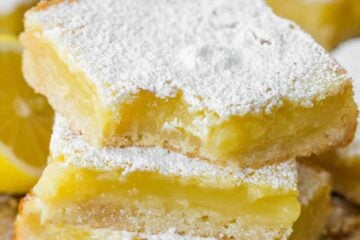 Lemon bars stacked and dusted with sugar