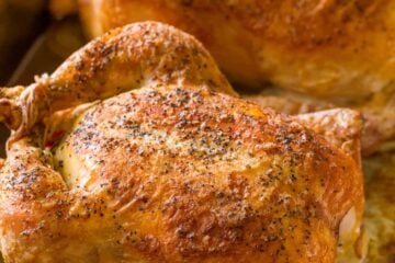Two roasted chickens in pan