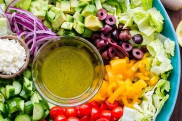 Chopped Greek Salad with Lettuce served in a blue bowl with dressing