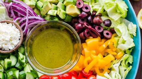 Chopped Greek Salad with Lettuce served in a blue bowl with dressing