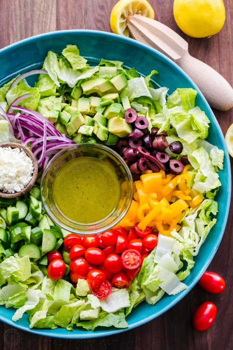 Chopped Greek Salad with Lettuce served in a blue bowl with dressing