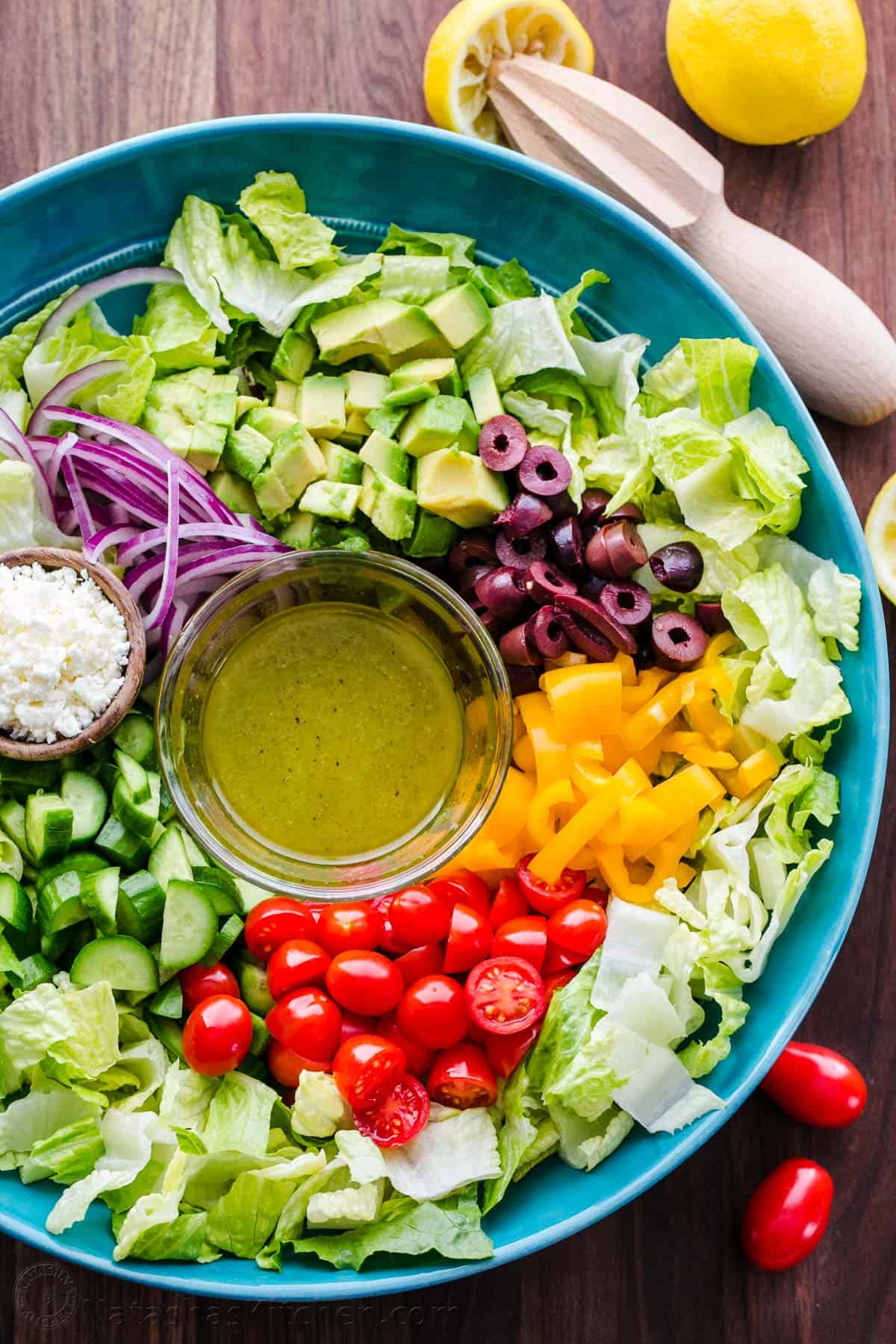 Chopped Greek Salad with Lettuce served in a blue bowl with dressing