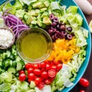 Chopped Greek Salad with lettuce recipe in a bowl with dressing