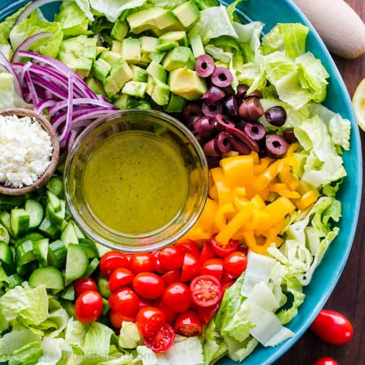 Chopped Greek Salad with lettuce recipe in a bowl with dressing