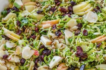 Shaved brussels sprouts salad with salad servers