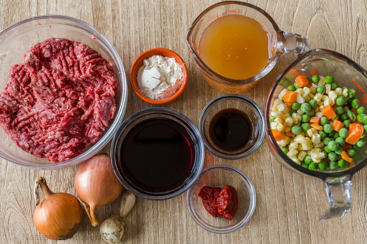 A homey and comforting Shepherd's Pie recipe with a meat and vegetable gravy sauce under a crown of creamy parmesan mashed potatoes. Ingredients for making shepherd's pie with ground beef and vegetables