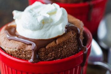 Chocolate souffle served in cups with whipped cream and chocolate sauce