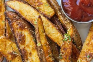 baked potato wedges on plate served with ketchup
