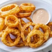 Onion rings on plate with dipping sauce