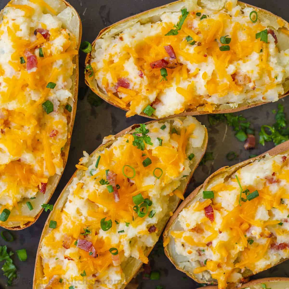 twice baked potatoes served on a baking sheet garnished with chives