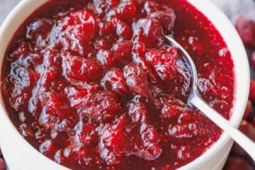 A bowl of homemade cranberry sauce with a spoon.