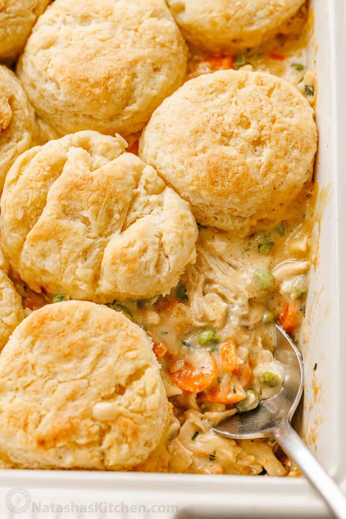Chicken Pot Pie Casserole has all the same cozy flavors we love, but it's so easy to bake in a casserole dish, topped with flaky biscuits. Up close chicken pot pie casserole with gravy filling and biscuits