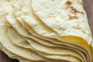 A stack of homemade flour tortillas folded in half.