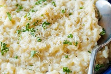 Risotto in blue bowl garnished with parmesan and parsley