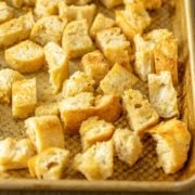 Homemade croutons on a metal baking sheet.
