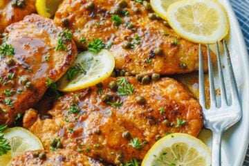 Easy Chicken piccata recipe served on a dish with lemon slices and capers
