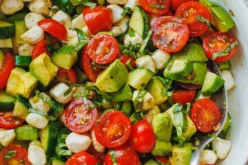 tomato cucumber mozzarella salad in a bowl with a spoon