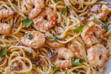 Tuscan Shrimp Pasta with sun-dried tomatoes in a stainless steel pan