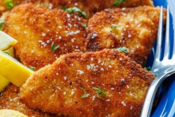 Crispy Chicken Schnitzel on a plate with lemon wedges