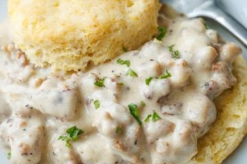 Close up of homemade biscuits and gravy on a plate with a fork