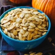Roasted pumpkin seeds served in a blue bowl