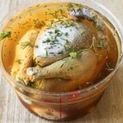 A whole turkey soaking in a salted, herbal brine
