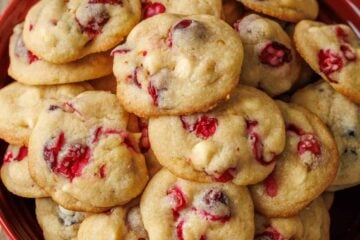 White chocolate cranberry cookies stacked on a red platter