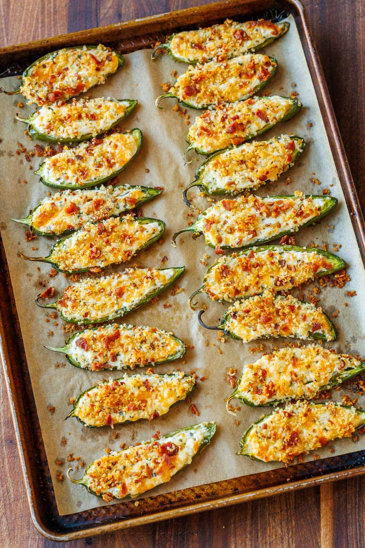 This easy Jalapeno popper recipe is delicious, with a cheesy filling and crisp bacon crumb topping. This crowd-pleasing appetizer goes fast! Tray of Jalapeno poppers with crispy bacon topping
