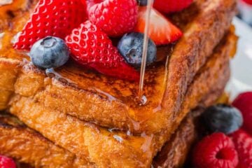 Stack of french toast served with berries and maple syrup